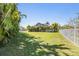 Expansive backyard featuring lush lawn, perimeter trees, and partial fencing for privacy at 824 Islebay Dr, Apollo Beach, FL 33572