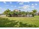 Expansive backyard with lush lawn, mature palms, and a charming screened-in pool area at 824 Islebay Dr, Apollo Beach, FL 33572