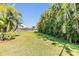 Large backyard with lush green lawn, privacy hedges, and white picket fence at 824 Islebay Dr, Apollo Beach, FL 33572