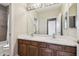 Bathroom with dual sinks, a large mirror, and a tiled shower, offering convenience and style at 824 Islebay Dr, Apollo Beach, FL 33572