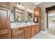Bathroom with double vanity, wood cabinets, and decorative mirrors at 824 Islebay Dr, Apollo Beach, FL 33572