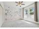 Bright bedroom features a whimsical wall mural, neutral rug, and ample natural light at 824 Islebay Dr, Apollo Beach, FL 33572