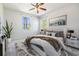 Bright bedroom with an upholstered headboard, bedside tables, ceiling fan, and outdoor views from the windows at 824 Islebay Dr, Apollo Beach, FL 33572