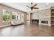 Living room with stone fireplace, neutral colors, tile floor and large windows to the outdoor space at 824 Islebay Dr, Apollo Beach, FL 33572