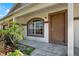 Inviting home entrance with a covered porch, decorative window, and freshly painted front door at 8551 N Hyaleah Rd, Tampa, FL 33617