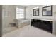 Luxurious primary bathroom with dual vanity, soaking tub, glass-enclosed shower, and modern fixtures at 8714 Sandy Plains Dr, Riverview, FL 33578