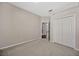 Spacious bedroom with neutral walls, carpet flooring, closet, and door to a hallway at 8714 Sandy Plains Dr, Riverview, FL 33578