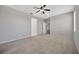 Bright bedroom featuring neutral walls, carpet, ceiling fan, and two entry doors at 8714 Sandy Plains Dr, Riverview, FL 33578