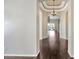 Hallway featuring hardwood floors, archways, decorative lighting, and access to multiple rooms at 8714 Sandy Plains Dr, Riverview, FL 33578