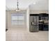Kitchen area with stainless steel appliances, tile flooring, a window, and adjacent dining space at 8714 Sandy Plains Dr, Riverview, FL 33578