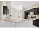 Bright kitchen featuring granite counters, stainless appliances, dark cabinets, and tile backsplash at 8714 Sandy Plains Dr, Riverview, FL 33578
