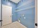 Laundry room with blue walls, tile flooring, wire shelving, and washer/dryer hookups at 8714 Sandy Plains Dr, Riverview, FL 33578