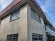 Upward angled exterior view of building with stucco walls and red tile roof at 10039 62Nd N Ave # 14, St Petersburg, FL 33708