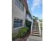 Exterior view of a building, showing landscaping and stairway to upper level at 10039 62Nd N Ave # 14, St Petersburg, FL 33708