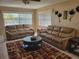 A living room with brown leather sofas, area rug, and lots of natural light from the windows at 10039 62Nd N Ave # 14, St Petersburg, FL 33708