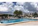 Community pool area with lounge chairs and view of the lake and buildings on a sunny day at 10039 62Nd N Ave # 14, St Petersburg, FL 33708