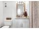 Bathroom featuring granite countertops, a decorative mirror and modern white cabinets at 113 Seahorse Se Dr # D, St Petersburg, FL 33705