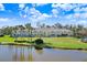 Beautiful view of two story condos overlooking lake with lovely reflection, green lawn, and palm trees at 113 Seahorse Se Dr # D, St Petersburg, FL 33705