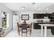 Bright kitchen and dining area with granite countertops, dark cabinets and white tile floors at 113 Seahorse Se Dr # D, St Petersburg, FL 33705