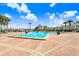Community pool area with lounge chairs, palm trees and condo buildings in the background at 113 Seahorse Se Dr # D, St Petersburg, FL 33705