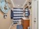 Nautical-themed bathroom with blue and white stripes, anchor decorations, and a single sink vanity at 11434 Minnieola Dr, New Port Richey, FL 34654