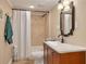 Standard bathroom with a shower-tub combination, single sink vanity, and neutral tile flooring at 11434 Minnieola Dr, New Port Richey, FL 34654