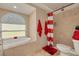 Bright bathroom featuring a soaking tub with tile surround and walk-in shower with red accents at 11434 Minnieola Dr, New Port Richey, FL 34654