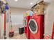 Functional laundry room with red washer and dryer set, with storage shelves above, next to a window at 11434 Minnieola Dr, New Port Richey, FL 34654
