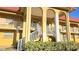 Exterior shot of building with yellow facade, white stair railings, and beautiful landscaping at 1301 S Hercules Ave # 3, Clearwater, FL 33764