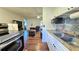 Galley kitchen showing granite countertops, white cabinets, and stainless steel appliances at 1301 S Hercules Ave # 3, Clearwater, FL 33764