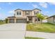 Inviting two-story home with three-car garage, tidy landscaping, and classic architectural details at 13549 Willow Bluestar Loop, Riverview, FL 33579