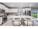 Spacious kitchen featuring a large center island with seating, stainless steel appliances, and white cabinets at 13549 Willow Bluestar Loop, Riverview, FL 33579