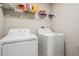 Laundry room with a washer, a dryer, and shelving at 13549 Willow Bluestar Loop, Riverview, FL 33579