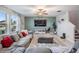 Living room featuring a large sectional sofa, ceiling fan, and accent wall with TV at 13549 Willow Bluestar Loop, Riverview, FL 33579