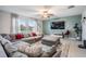 Bright living room featuring a large sectional sofa, accent wall, and ample natural light from the windows at 13549 Willow Bluestar Loop, Riverview, FL 33579