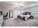 Spacious main bedroom with a ceiling fan, carpeted floor, and natural light at 13549 Willow Bluestar Loop, Riverview, FL 33579