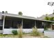 Exterior view of a screened-in patio with lush landscaping in the backyard at 1519 Delaware Ne Ave, St Petersburg, FL 33703