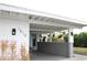 View of the home's carport with white wood and brick accents, as well as greenery at 1519 Delaware Ne Ave, St Petersburg, FL 33703