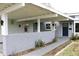 View of a front entry and carport with brick accents and hanging flower baskets at 1519 Delaware Ne Ave, St Petersburg, FL 33703