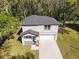 Aerial view of a modern home featuring a gray roof, manicured lawn and a long driveway at 16417 Lake Byrd Dr, Tampa, FL 33618
