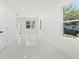 Well-lit living room with white floors and walls, featuring views to the outside at 16417 Lake Byrd Dr, Tampa, FL 33618