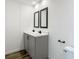 This modern bathroom features double sinks, black hardware and wood-look flooring at 18079 Carrolwood Dr, Brooksville, FL 34604