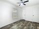This bedroom features a ceiling fan, a window with natural light, and wood-look flooring at 18079 Carrolwood Dr, Brooksville, FL 34604