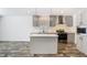 Modern kitchen featuring gray cabinets, stainless steel appliances, quartz countertops and luxury vinyl plank flooring at 18079 Carrolwood Dr, Brooksville, FL 34604