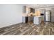 Open kitchen with gray cabinets, stainless appliances, an island, and stylish pendant lighting at 18079 Carrolwood Dr, Brooksville, FL 34604