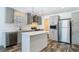 This kitchen features gray cabinets, stainless steel appliances, and wood-look floors at 18079 Carrolwood Dr, Brooksville, FL 34604