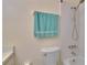 Bright bathroom featuring a tiled shower, a blue towel, and a white toilet at 1902 Dandridge St # 6, Sun City Center, FL 33573
