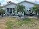 Charming home exterior featuring a well-manicured lawn, palm trees, patio seating, and golf cart at 1902 Dandridge St # 6, Sun City Center, FL 33573