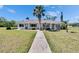 Charming single-story home with a well-maintained lawn, mature landscaping, and a welcoming walkway leading to the front door at 1902 Dandridge St # 6, Sun City Center, FL 33573