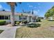 Charming single-story home with well-maintained landscaping featuring mature trees, shrubs, and a walkway leading to the front door at 1902 Dandridge St # 6, Sun City Center, FL 33573